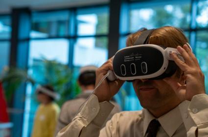 Participant wearing Metaverse goggles with the EEA and Norway Grants logo on them 