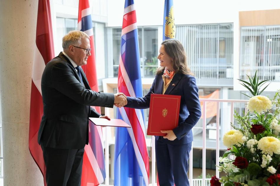 People on stage shaking hands, holding the freshly signed MoUs