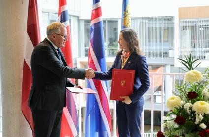 People on stage shaking hands, holding the freshly signed MoUs