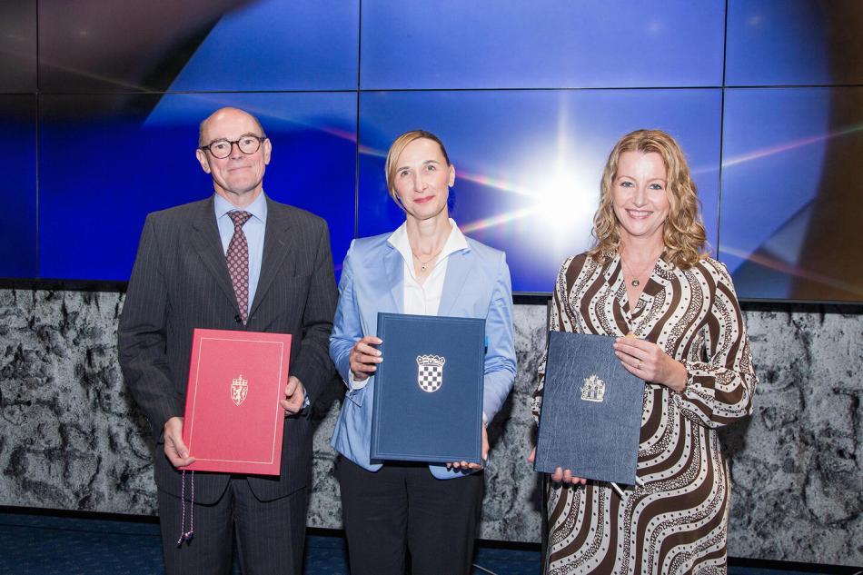 People on stage holding the freshly signed MoUs