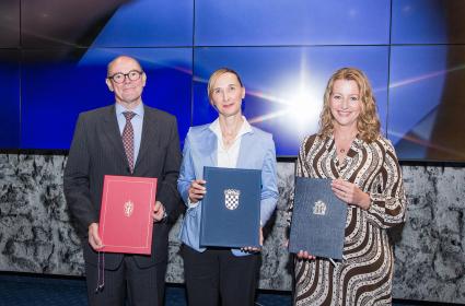 People on stage holding the freshly signed MoUs