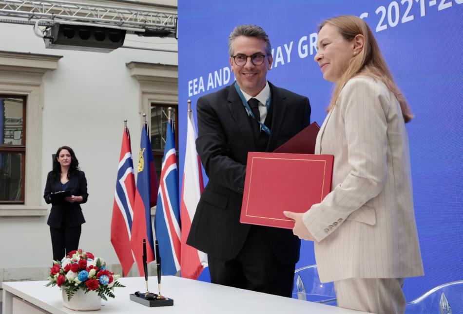 Uścisk dłoni po podpisaniu umów wymieniają Pascal Schafhauser, ambasador Liechtensteinu przy Unii Europejskiej oraz Katarzyna Pełczyńska-Nałęcz, Minister Funduszy i Polityki Regionalnej 